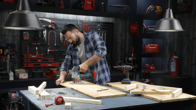 a man cutting wood to make the tabletop