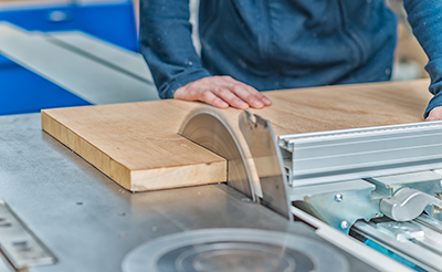 A table saw trims down a large piece of lumber.