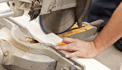 A board is cut using a miter saw.