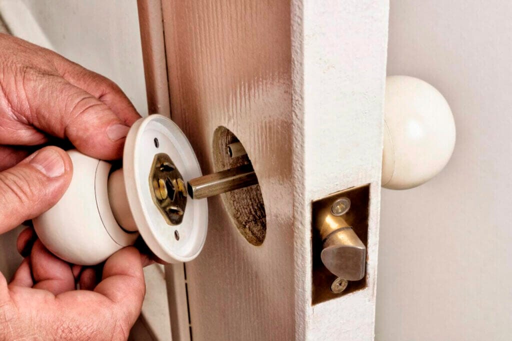 Close up of a hand installing a new latch